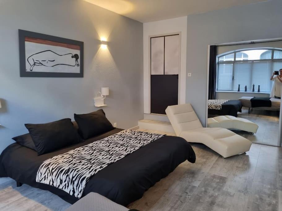 a bedroom with a bed and a living room at Grand appartement près de la Cathédrale de Quimper in Quimper