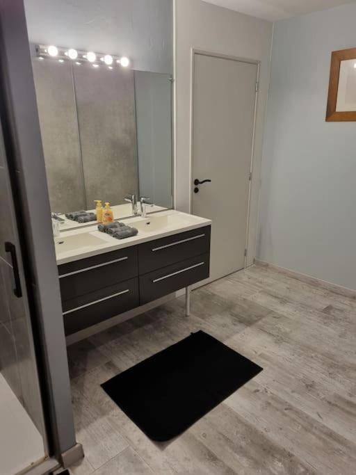 a bathroom with a sink and a large mirror at Grand appartement près de la Cathédrale de Quimper in Quimper