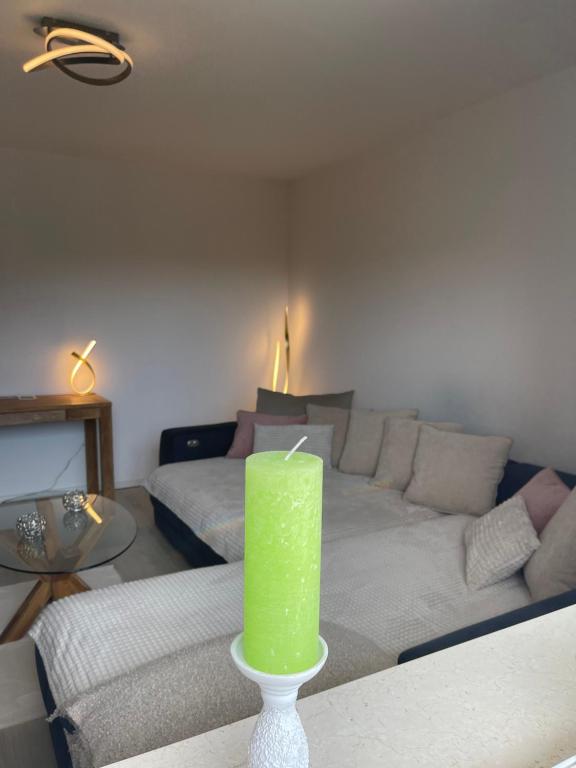 a green candle sitting on a table in a living room at Albblick in Albstadt