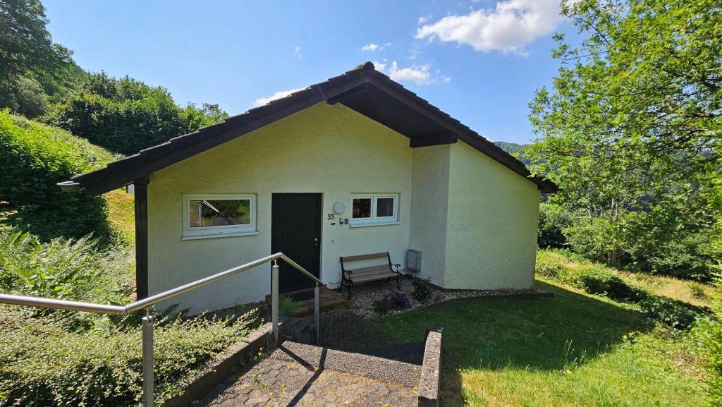 una pequeña casa en un campo con porche en Landhaus-Wald-und-See-1, en Koosbüsch
