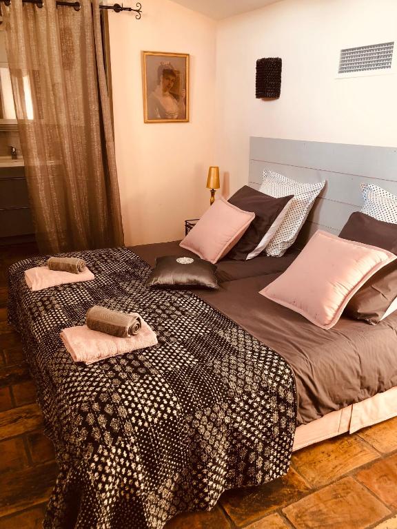 a large bed with two pillows on top of it at Au bout du pré in Pézenas