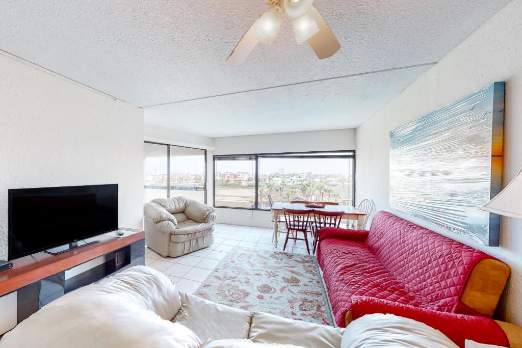 salon z czerwoną kanapą i telewizorem z płaskim ekranem w obiekcie Bay Stay w mieście South Padre Island