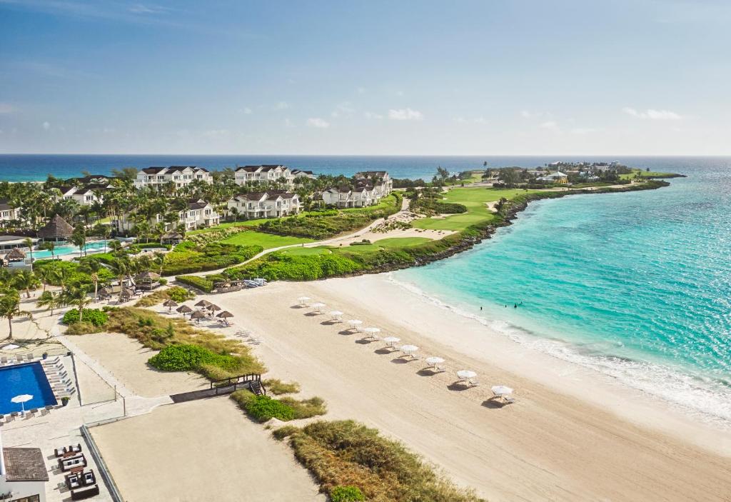 an aerial view of a beach with chairs and the ocean at Grand Isle Resort & Residences in Farmerʼs Hill