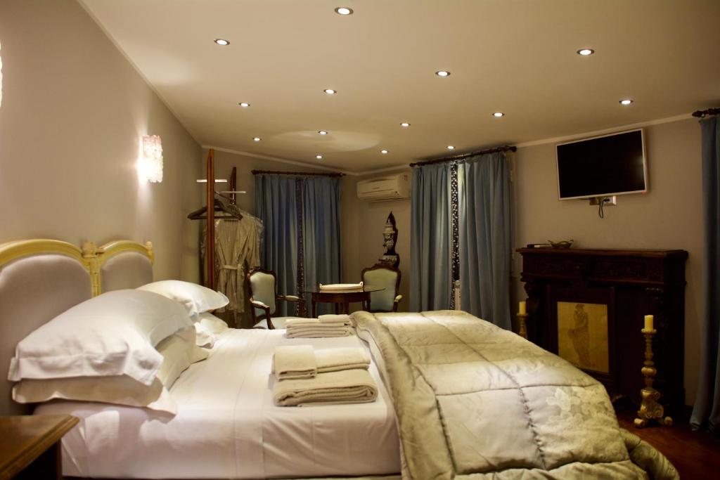 een slaapkamer met een wit bed en een tv aan de muur bij Twins Apartments in Sanremo