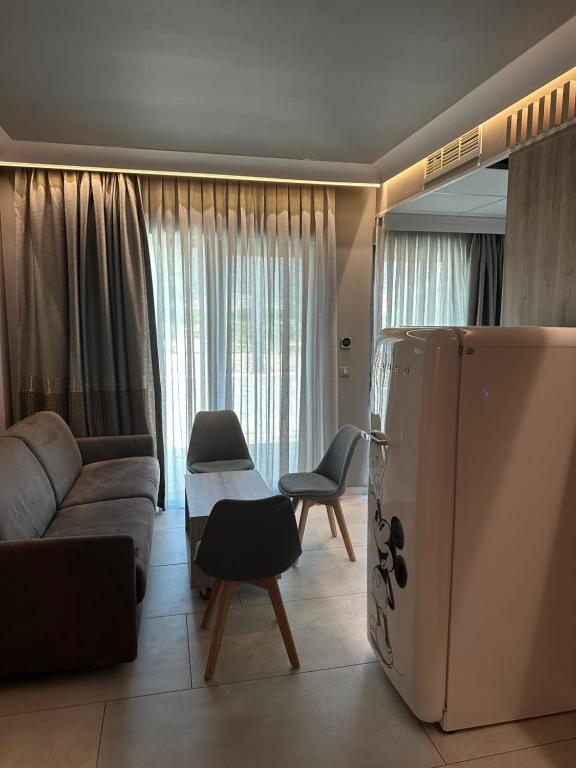 Barocco Island Studios في سكالا بوتامياس: غرفة معيشة مع أريكة وثلاجة