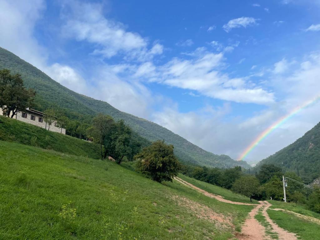 un arcobaleno su un campo con una strada sterrata di Casale nella valle a Pieve Torina