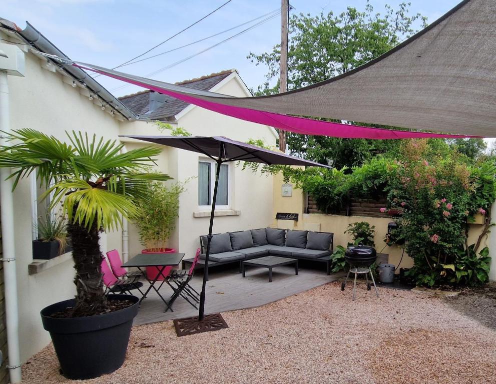 a patio with a couch and an umbrella at "Ô Tour's Angels" FEBVOTTE in Tours