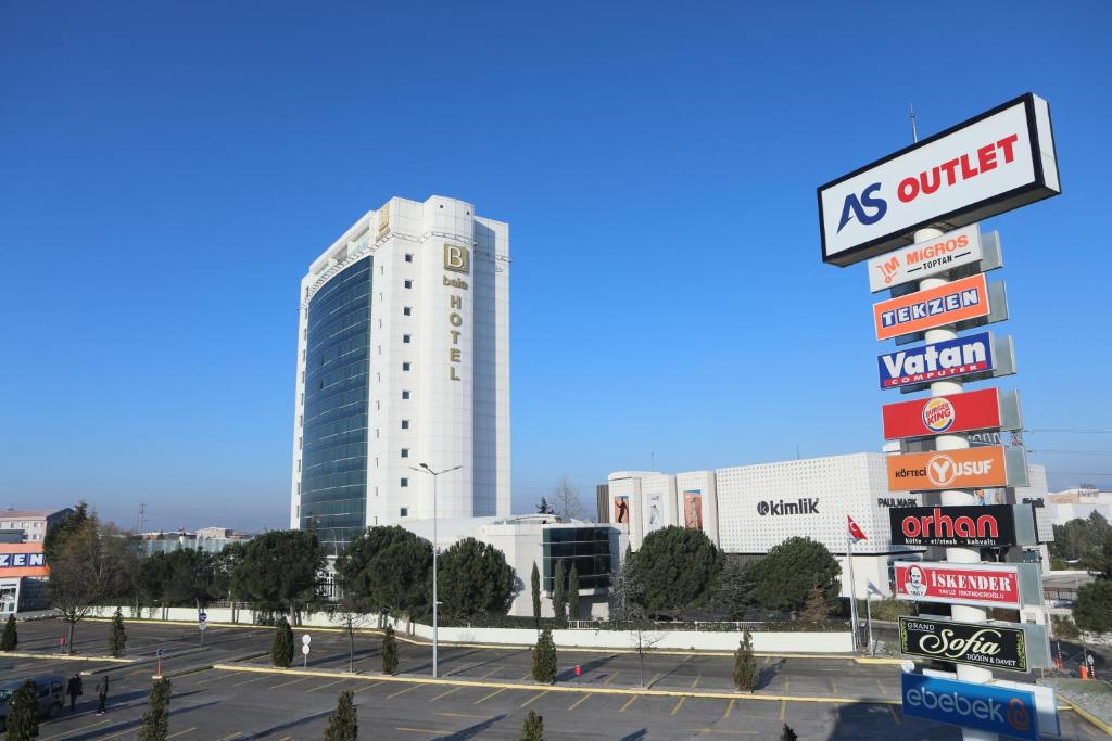 un edificio blanco alto con muchas señales en un estacionamiento en Baia Bursa Hotel en Bursa