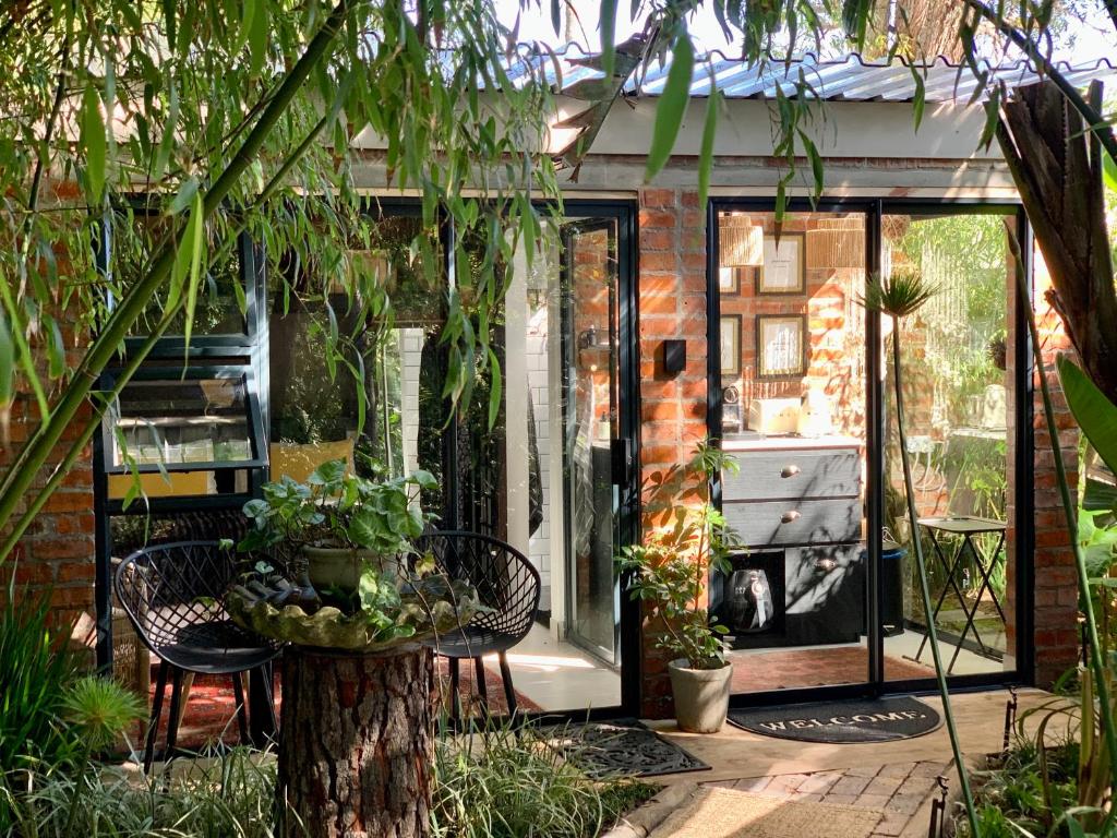 a conservatory with a table and chairs and plants at The Secret Garden Hideaway in Mossel Bay