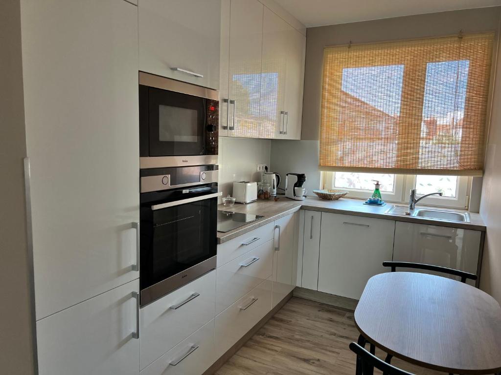 a kitchen with white cabinets and a black oven at Apartament BARI in Świnoujście