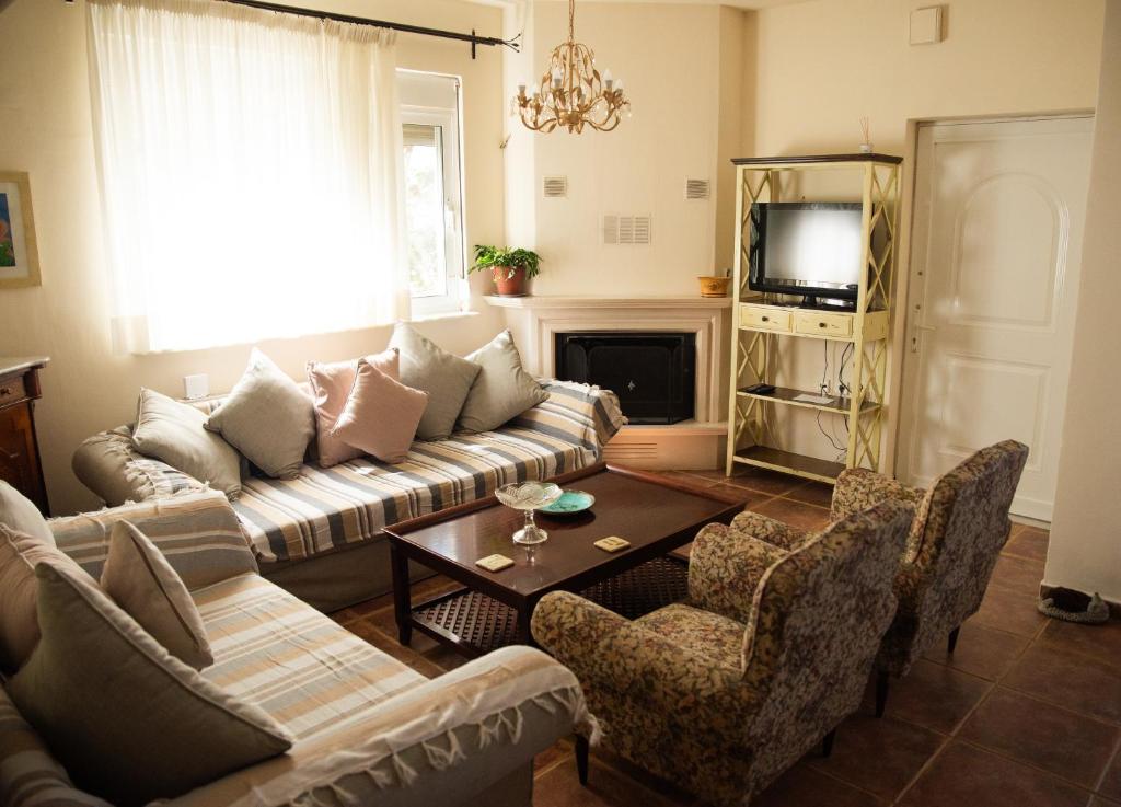 a living room with a couch and chairs and a table at The Early Bird - Cosy 2-Floor House with Garden in Alexandroupoli
