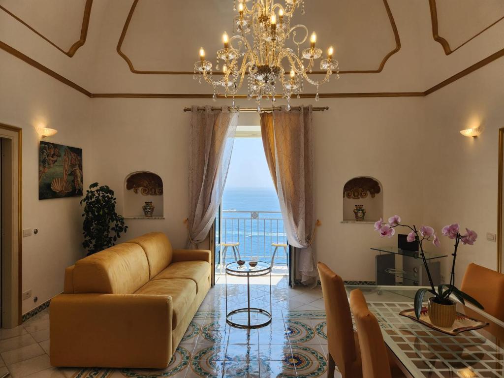 Palazzo Rocco - Golden Suite - Praiano - Amalfi Coast في برايانو: غرفة معيشة مع أريكة وثريا