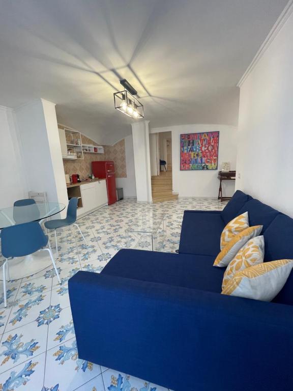 a living room with a blue couch and a table at Caterina 70 in Naples