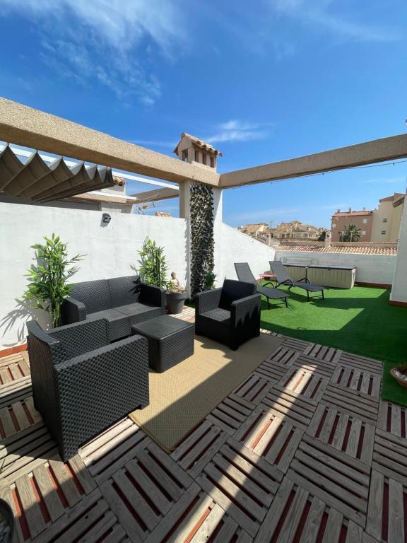 patio z kanapą i krzesłami na dachu w obiekcie Przytulny Apartament 100m od plaży w mieście Torrevieja
