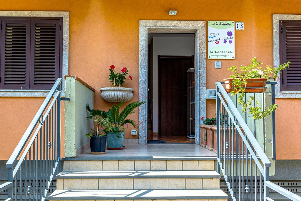 una escalera que conduce a una casa con macetas en Villetta Mari e Amuri, en Giardini Naxos