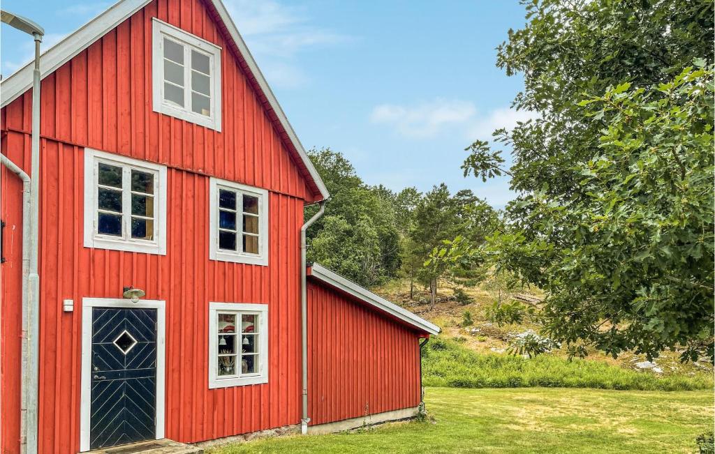 龍訥比的住宿－Stunning Home In Ronneby With Kitchen，红色谷仓,设有白色的窗户和门