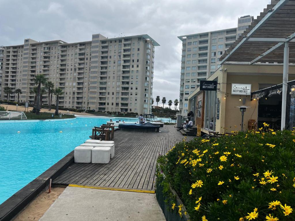 uma piscina com algumas cadeiras e alguns edifícios em RESETEATE EN FAMILIA ALGARROBO em Algarrobo