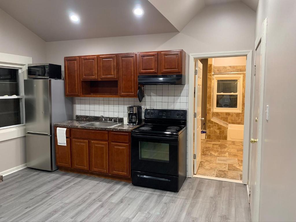 a kitchen with wooden cabinets and a stove top oven at Modern Couples Retreat in Newark