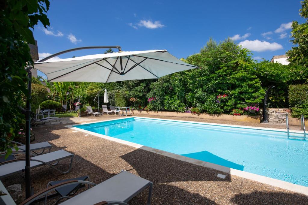 - Piscina con sombrilla, sillas y mesa en The Originals City, Hôtel de Bordeaux, Bergerac (Inter-Hotel), en Bergerac