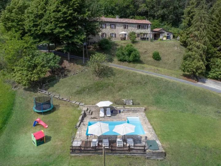 una vista aérea de un patio trasero con piscina y sombrillas en Casa Domenica - Home&more, en Monastero Bormida