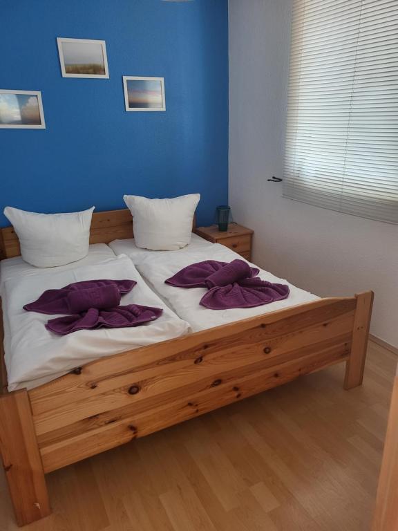een slaapkamer met een bed met paarse kussens erop bij Bungalow Usedom in Ostseebad Koserow