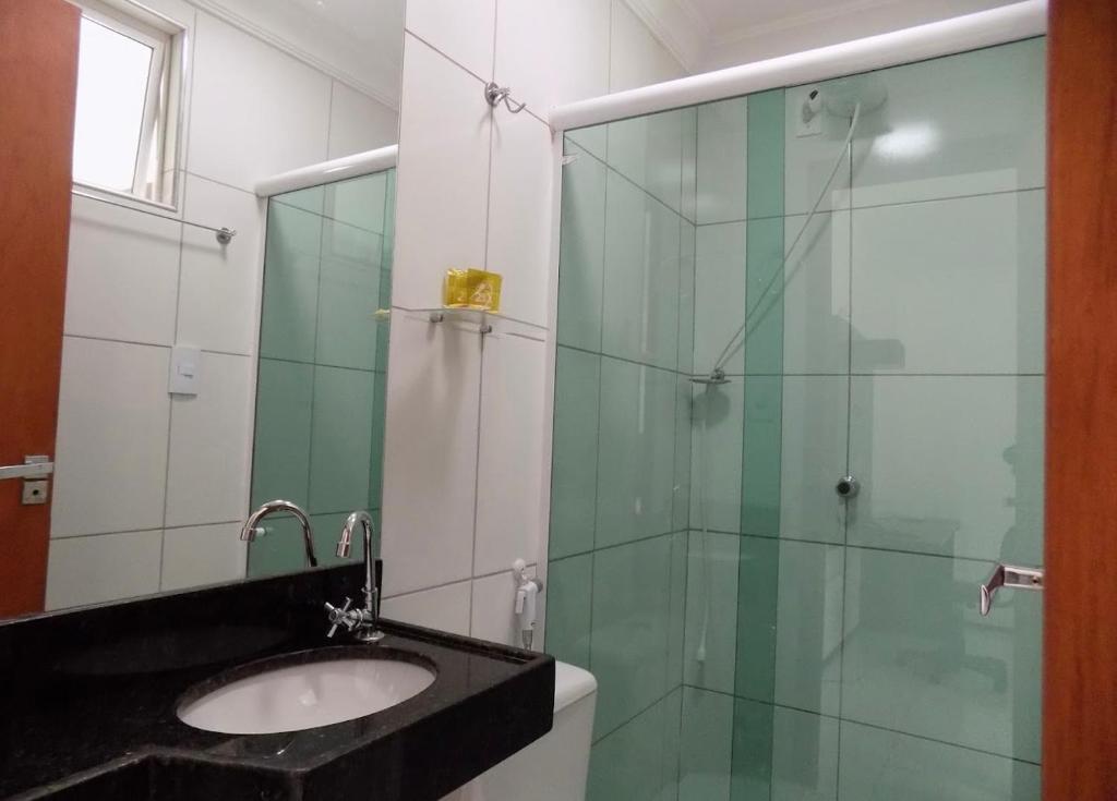 W łazience znajduje się umywalka i przeszklony prysznic. w obiekcie SP Hotel Fortaleza w mieście Fortaleza