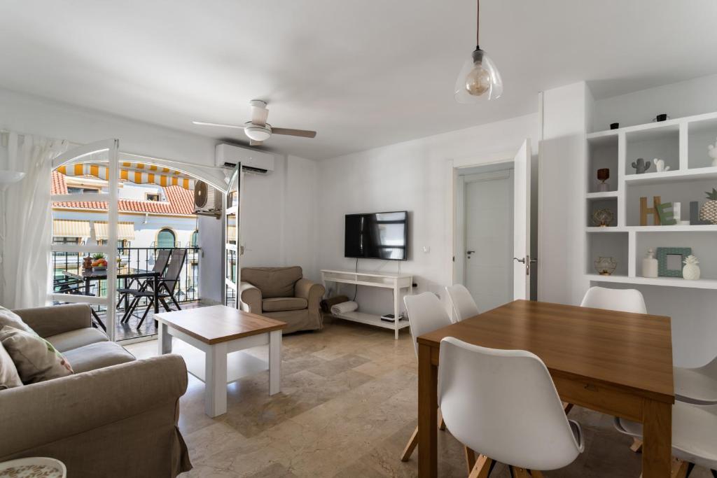 a living room with a table and a dining room at Sur Suites Los Patios in Fuengirola