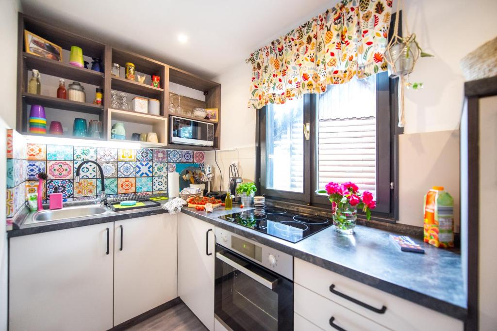 a kitchen with white cabinets and a sink and a window at Boho House 2 in camp Terme Catez in Čatež ob Savi