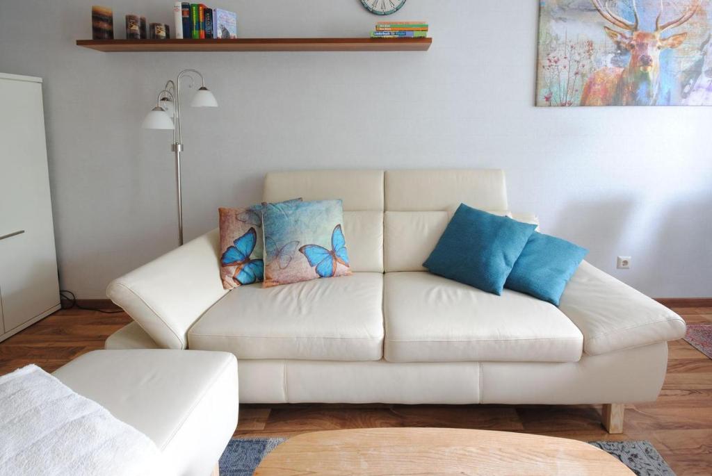- un salon avec un canapé blanc et des oreillers bleus dans l'établissement Ferienwohnung Schlüsselblume, à Altenau