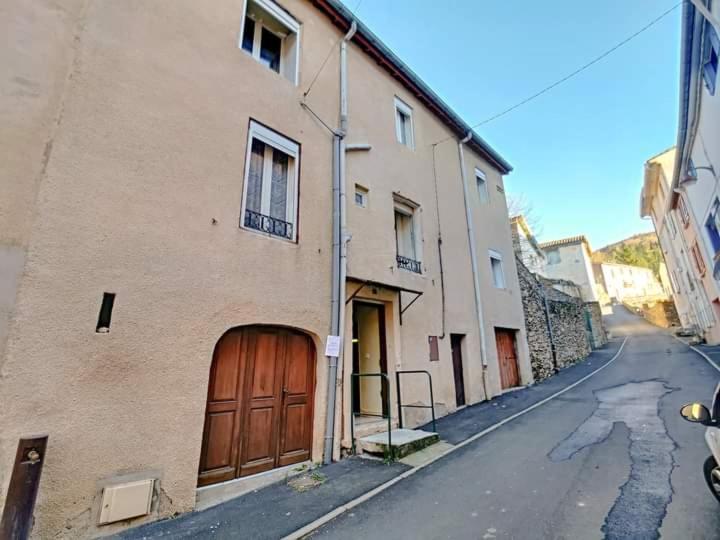 an alley with a building with a wooden door at Studio chemin compostelle in Saint-Gervais-sur-Mare