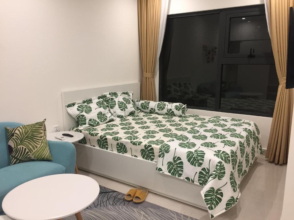 a bedroom with a bed with a green and white blanket at Vinhome Grand Park Homestay-HappyStay in Gò Công