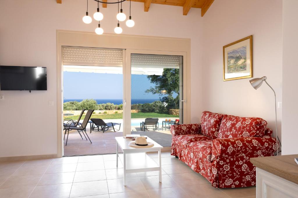 a living room with a red couch and a table at Villa Ruby in Pesádha