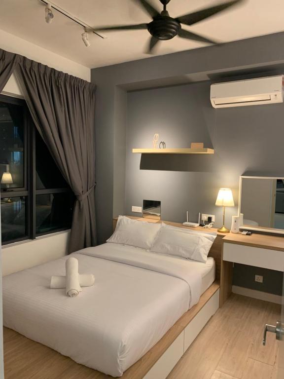 een slaapkamer met een bed, een bureau en een televisie bij FHS Homestay @ Arte Plus Jalan Ampang T2-11-02 in Kuala Lumpur