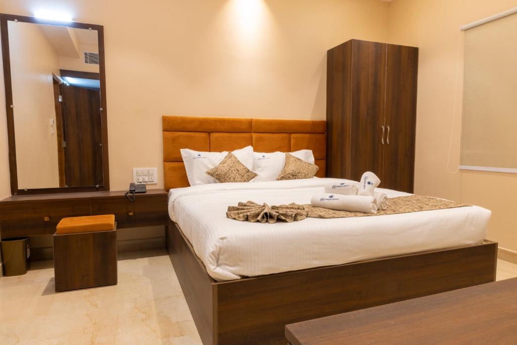 - une chambre avec un grand lit et un grand miroir dans l'établissement LK GRAND HOME, à Tirupati