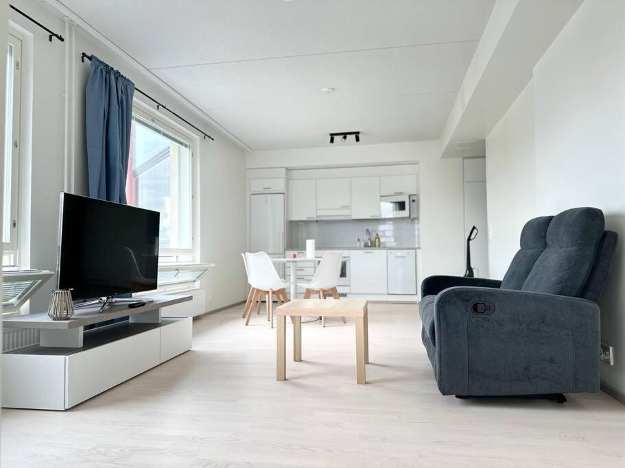 a living room with a tv and a couch and a chair at Huoneisto juna aseman vieressä in Vantaa