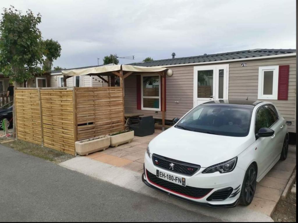 une voiture blanche garée devant une maison dans l'établissement Mobil home climatisé 6 personnes avec piscine, à Fréjus