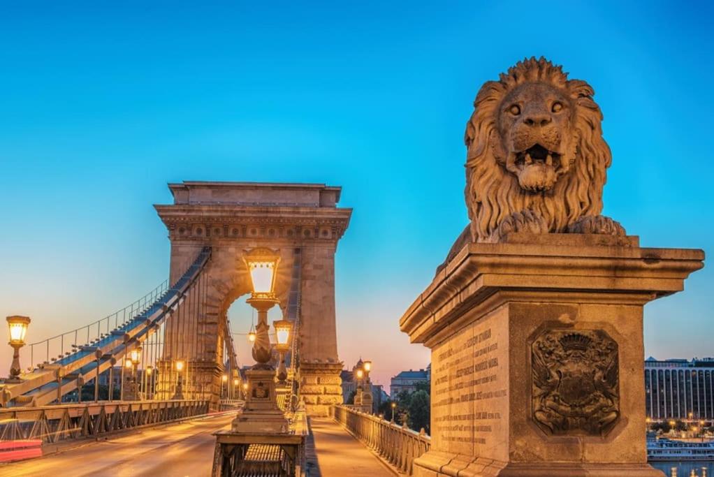 a lion statue on a bridge at night at Castle Chainbridge Apartment in Budapest