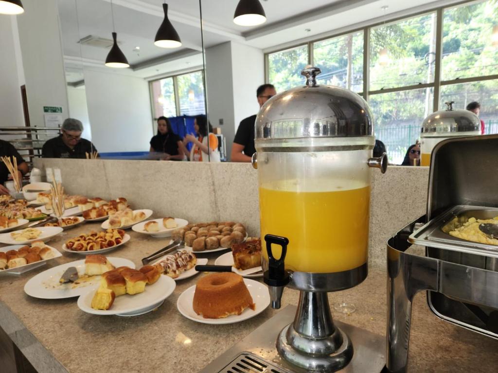a glass of orange juice sitting on a counter with food at Via Premiere Suite 710B in Rio de Janeiro