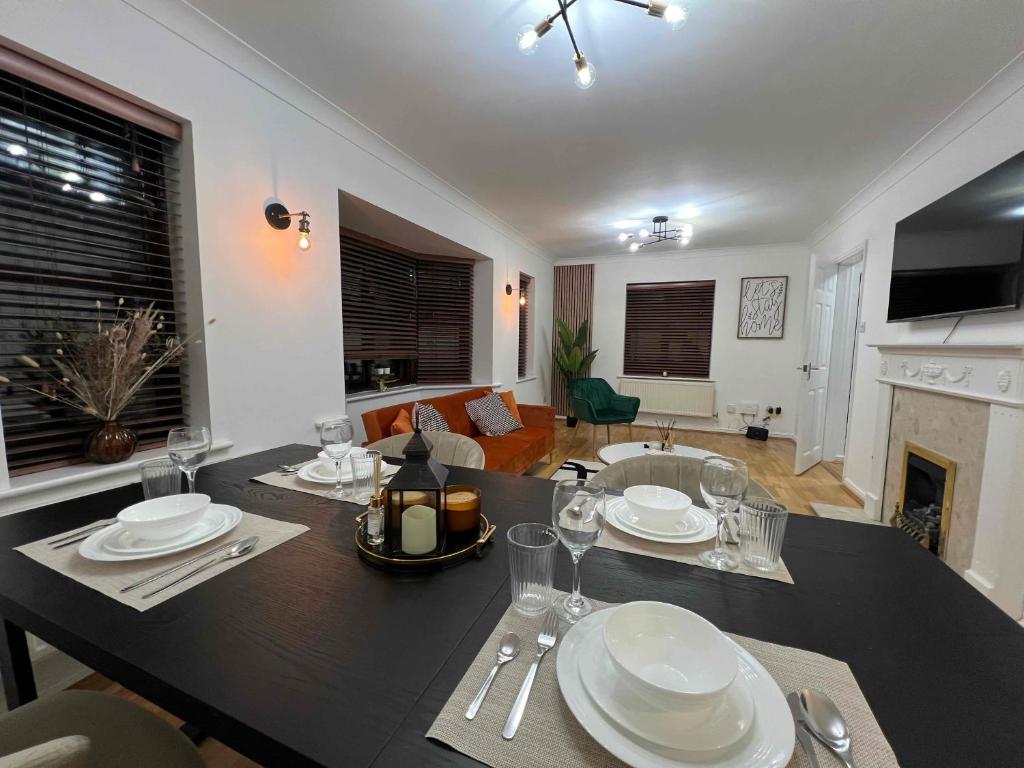 uma sala de jantar com uma mesa com pratos e copos de vinho em The Cosy Corner em Loughton