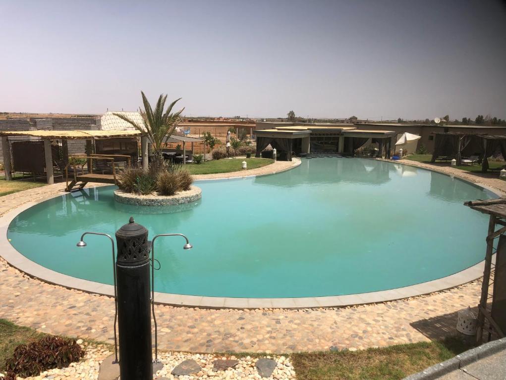 a large blue swimming pool in a yard at Dar Tiziri Amizmiz in Marrakech