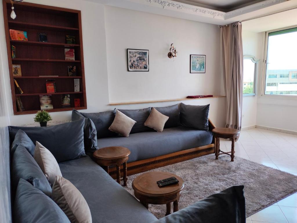 - un salon avec un canapé bleu et une table dans l'établissement Élégant appartement 3 chambres, à Rabat
