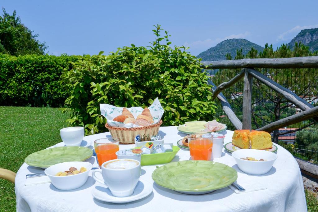 einen Tisch mit einem weißen Tischtuch mit Essen drauf in der Unterkunft Villevieille in Piano di Sorrento