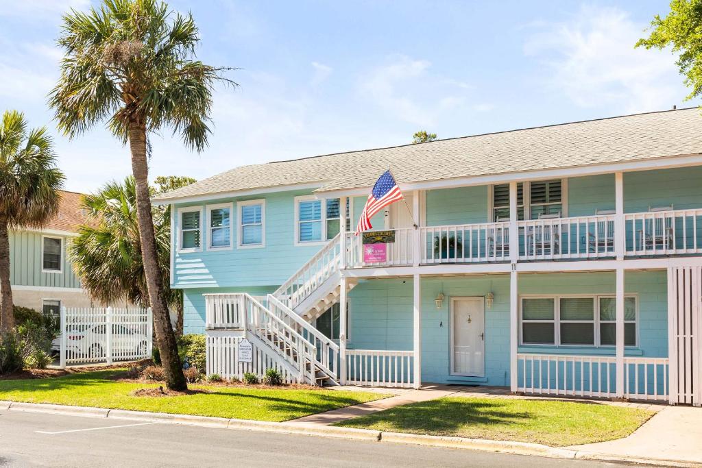a blue house with a balcony and an american flag at Colonels Retreat in Tybee Island