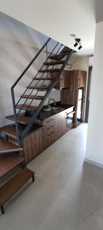 a staircase in a room with a sink and a kitchen at Welcome Inn in Paleo Tsifliki