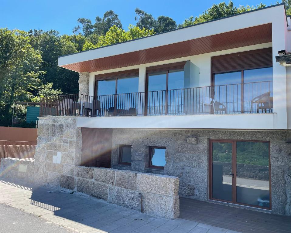 a stone house with a balcony on top of it at Casa do capitão A casa ideal para férias no Gerês in Vieira do Minho