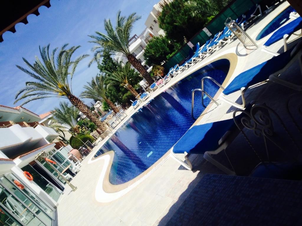 a large swimming pool at a resort with palm trees at M. Moniatis Hotel in Limassol