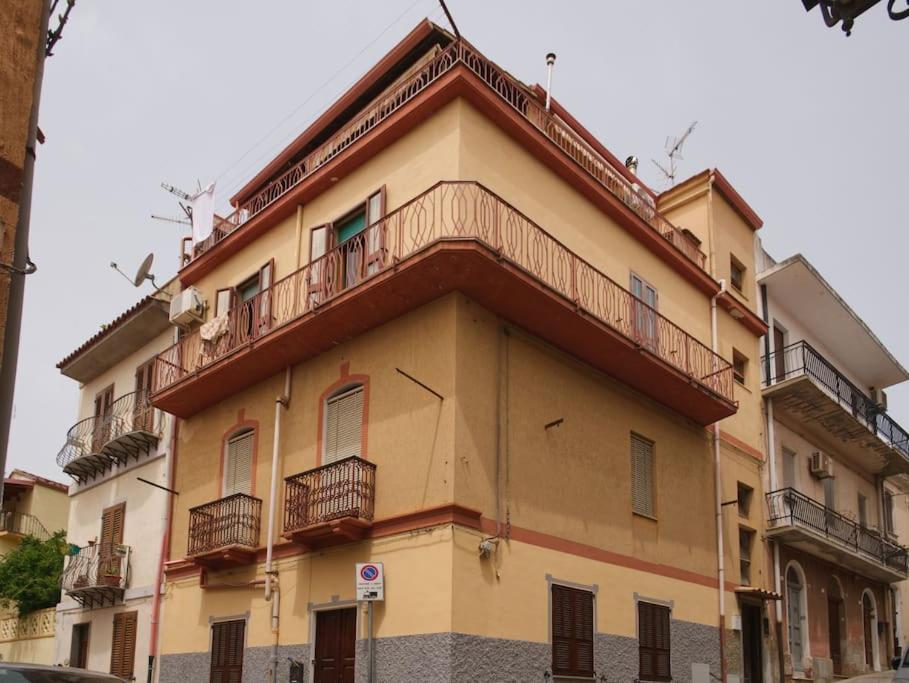 un edificio amarillo con balcones encima en Casa vacanze BellaVista en Iglesias