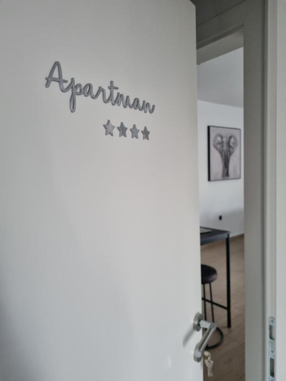 una habitación con una puerta con un cartel que lee apartamentos en Apartmani Toni, en Drniš