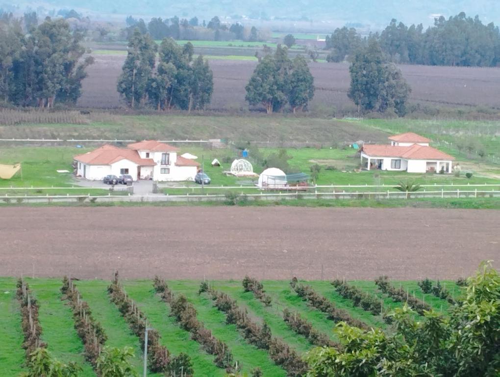 una granja con un campo de cultivos y casas en El Refugio de Santa Cruz, en Santa Cruz