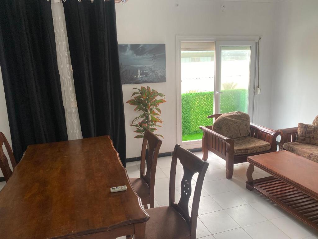 a living room with a wooden table and chairs at Akid in Oran